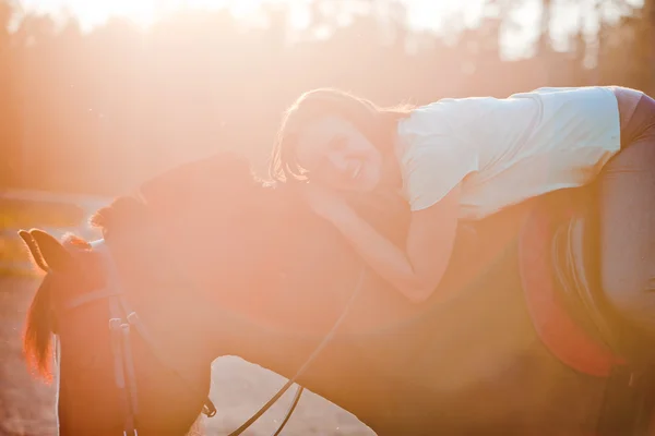Portrait of young woman on horse against the sun — Stock Photo, Image
