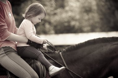 Mom and child  on the horse clipart