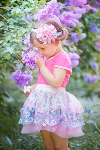 Ritratto di bambina in un giardino lilla — Foto Stock