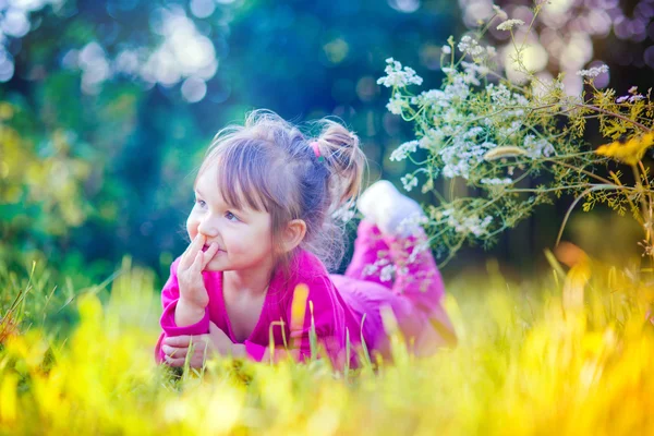 Söt liten flicka i blommor krans — Stockfoto