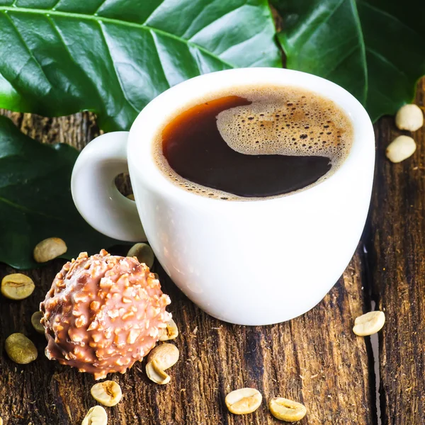 Cup of coffee with coffee tree leaves — Stock Photo, Image