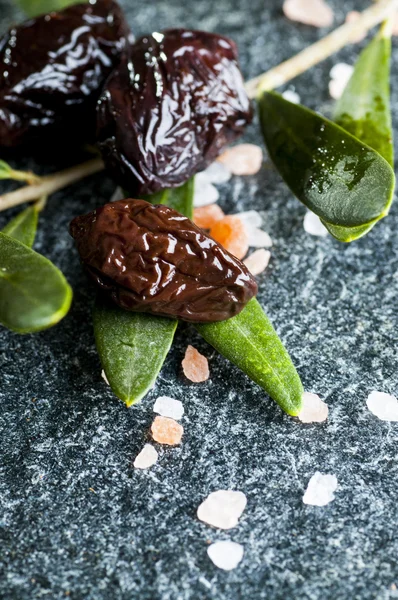 Sun-dried olives with green leaves — Stock Photo, Image