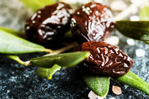 Sun sušených olivy se zelenými listy — Stock fotografie