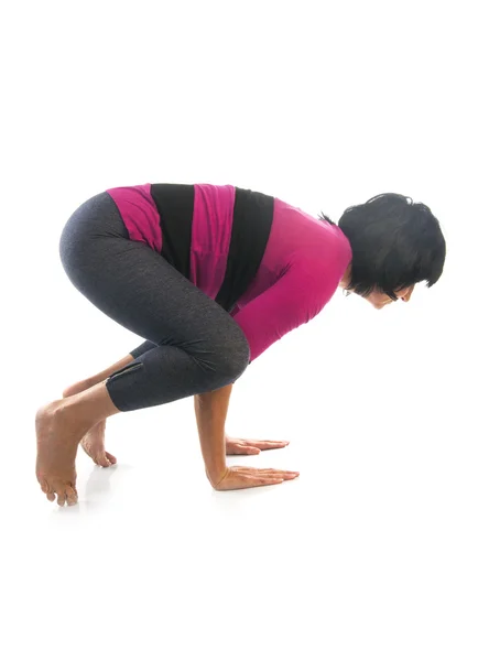 Mature woman in Bakasana yoga pose — Stock Photo, Image