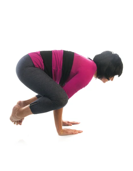 Mulher madura em Bakasana ioga pose — Fotografia de Stock