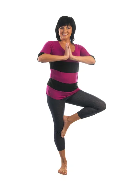 Zralá žena v Vrikshasana jóga pozice — Stock fotografie