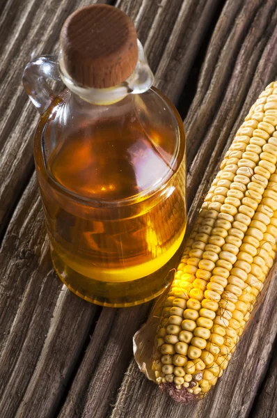 Сушеная кукуруза и бутылка масла — стоковое фото