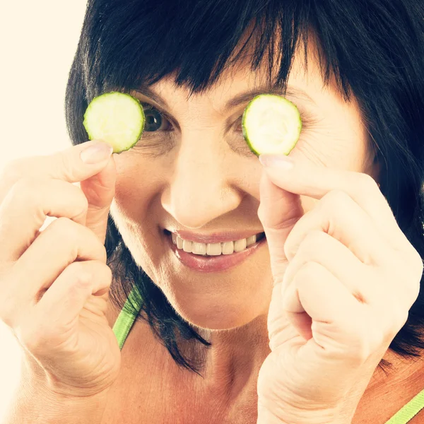 Mature holding slices of cucumber — Stock Photo, Image