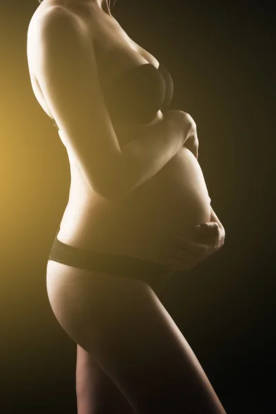 Беременная женщина держит живот — стоковое фото