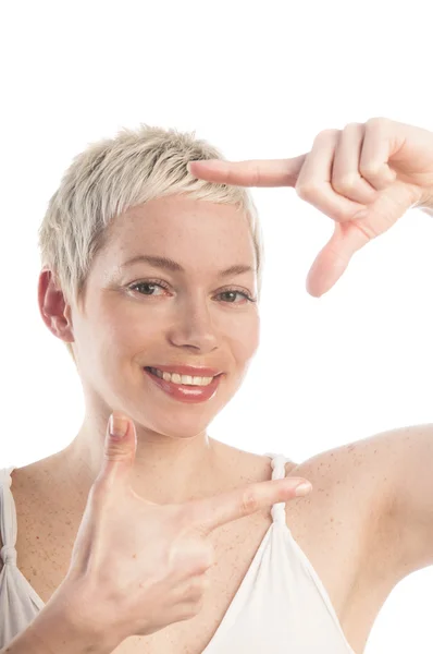 Woman looking at camera through finger frame — Stock Photo, Image