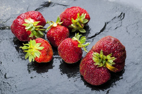 Ripe strawberries on black stone background — Stock Photo, Image
