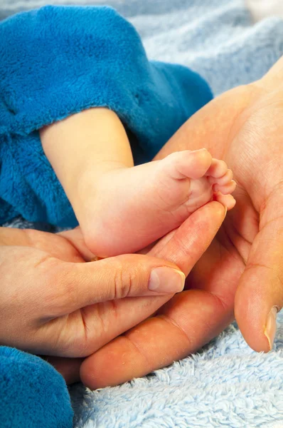 Baby leg in parents hands — Stock Photo, Image