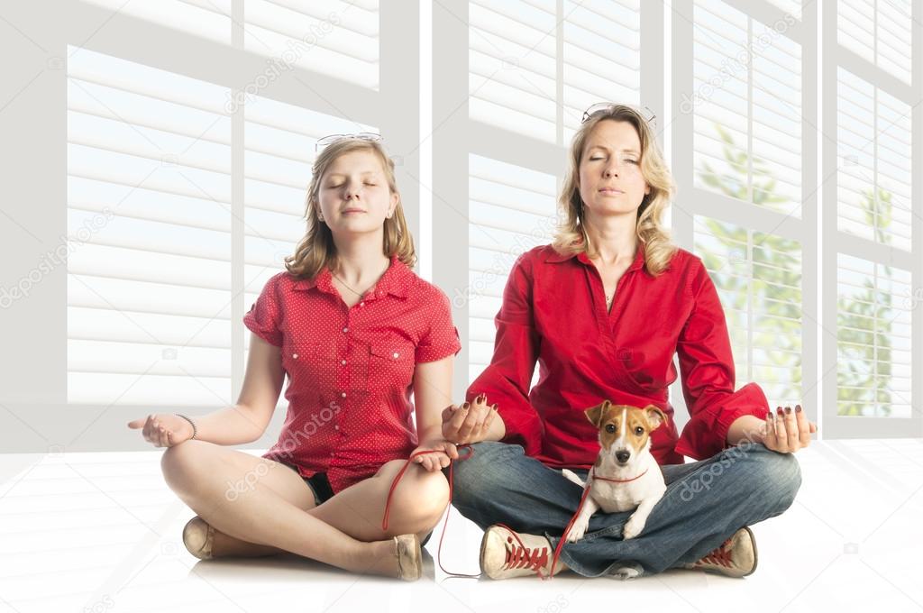 woman and girl in yoga pose with puppy