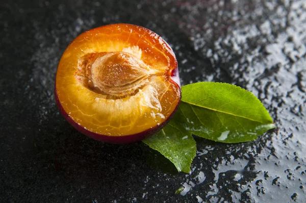 Reife Pflaume mit Blättern — Stockfoto