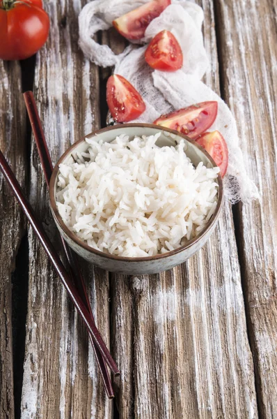 Rijst in een kom en gesneden tomaten — Stockfoto