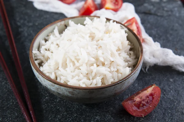 Reis in Schüssel und geschnittene Tomaten — Stockfoto