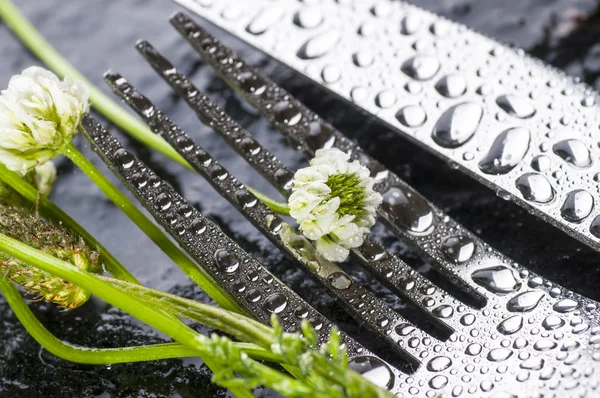 Tenedor y cuchillo con pequeñas flores blancas —  Fotos de Stock