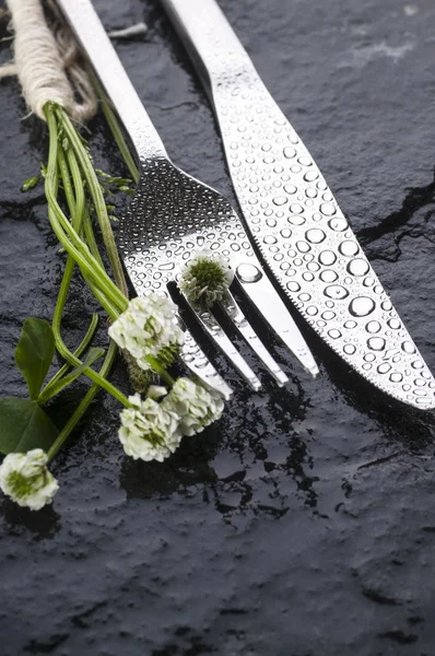 Vidlička a nůž s malými bílými kvítky — Stock fotografie