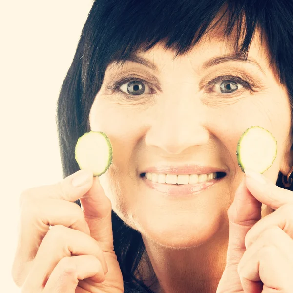 Mature holding slices of cucumber — Stock Photo, Image