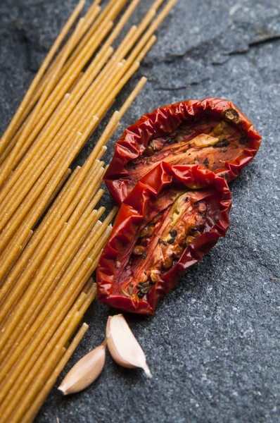 Macarrão de esparguete, tomate seco e alho — Fotografia de Stock