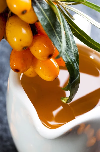 Sea buckthorns oil and berries — Stock Photo, Image