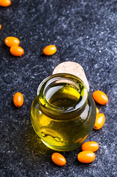 Sea buckthorns oil and berries — Stock Photo, Image