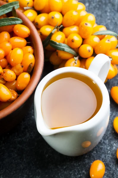 Sea buckthorns oil and berries — Stock Photo, Image