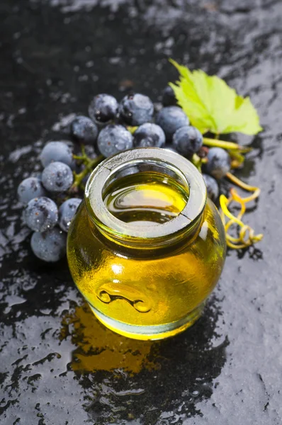 Grape seed oil and grapes bunch — Stock Photo, Image