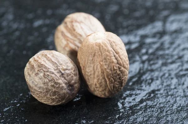 Nutmegs sobre fondo de piedra — Foto de Stock