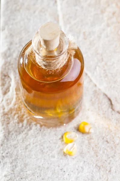 Corn seeds and oil bottle — Stock Photo, Image