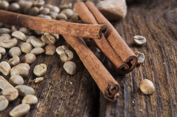 Green coffee beans with cinnamon sticks — Stock Photo, Image