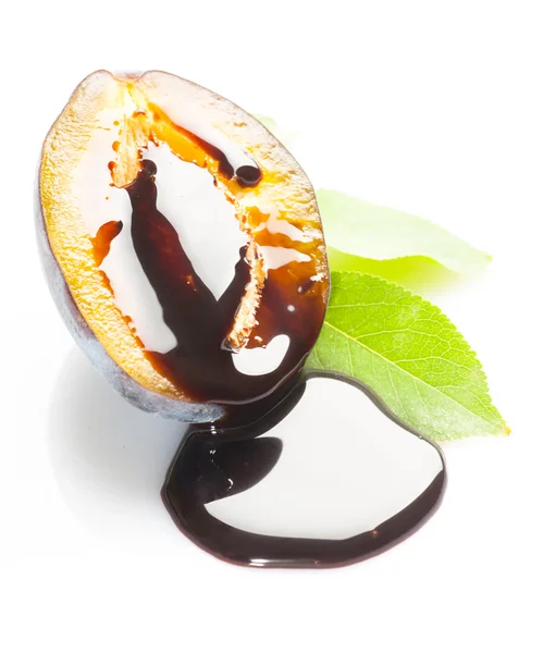 Ripe plum with chocolate syrup — Stock Photo, Image