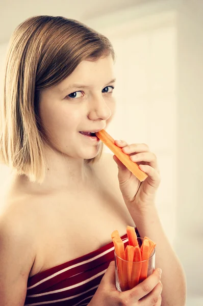 Menina adolescente comendo cenoura — Fotografia de Stock