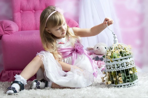 Niña sosteniendo jaula de aves con flores — Foto de Stock