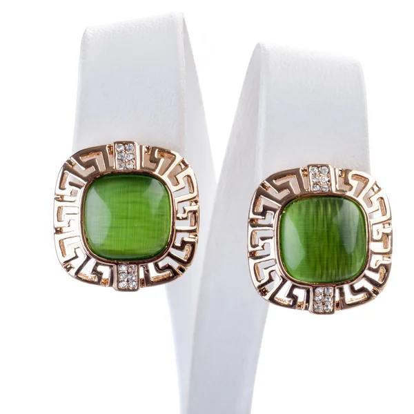 Golden earrings with green gemstones — Stock Photo, Image