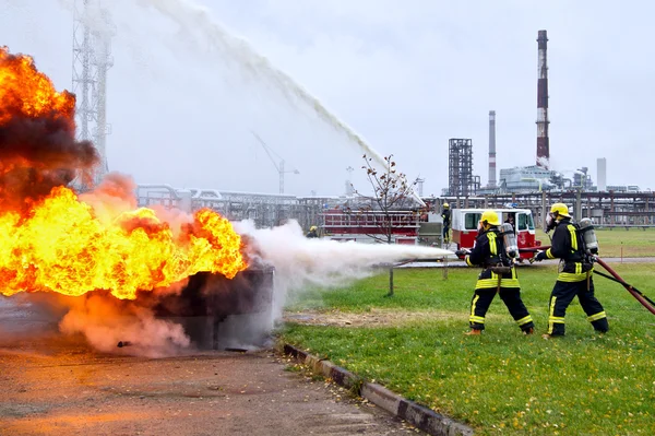 Re の背景に対して火を消火する消防士 — ストック写真