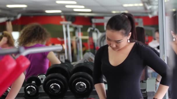 Çok oryantal kadın ağır egzersizler spor salonunda sahip — Stok video