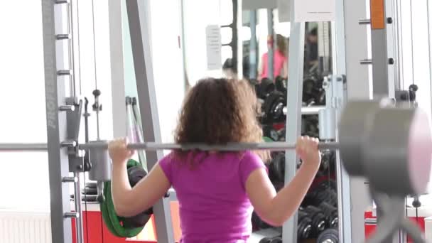 Mujer bonita haciendo ejercicio en el gimnasio — Vídeos de Stock