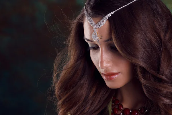 Krásná žena v zeleném indické sárí a šperky na barevné bac — Stock fotografie