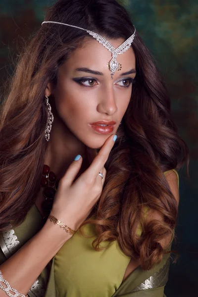 Belle femme en sari indien vert et bijoux sur bac coloré — Photo