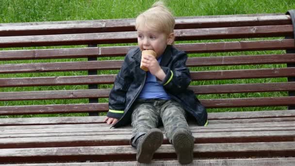 Happy kid boy eating ice cream outdoors, close up view — Stock Video