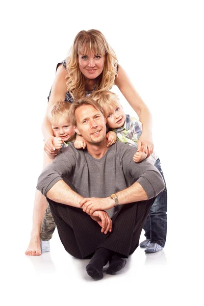 Kaukasier glücklich lächelnde junge Familie mit zwei Kindern im Sitzen — Stockfoto