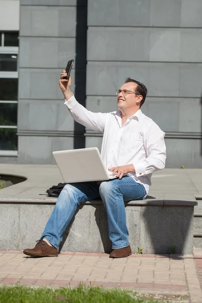 Erwachsener Mann mit Computer und Handy — Stockfoto