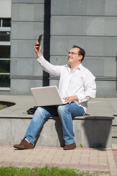 Uomo adulto con computer e telefono cellulare — Foto Stock