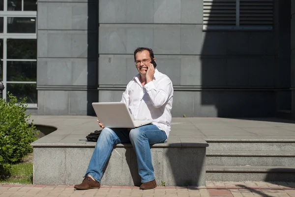 Erwachsener Mann mit Computer und Handy — Stockfoto