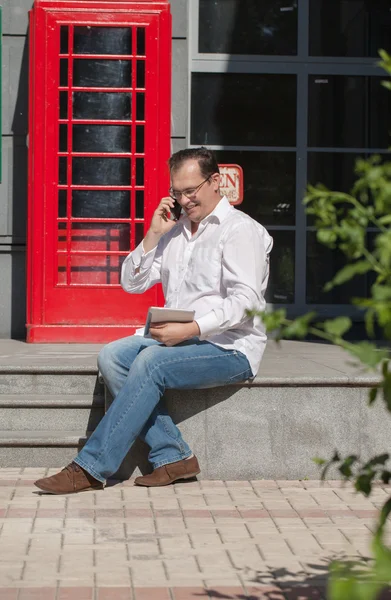 ビジネス男オン赤古典的な英語の電話ボックス — ストック写真