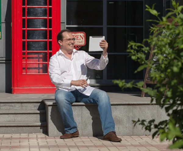 Affärsman på röd klassisk engelska telefonkiosk — Stockfoto