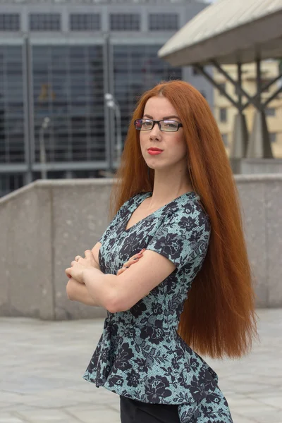 Red-haired woman on the background of office building — Stock Photo, Image