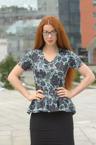 Femme rousse sur le fond de l'immeuble de bureaux — Photo