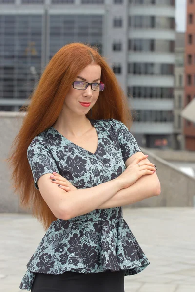 Red-haired woman on the background of office building — Stock Photo, Image